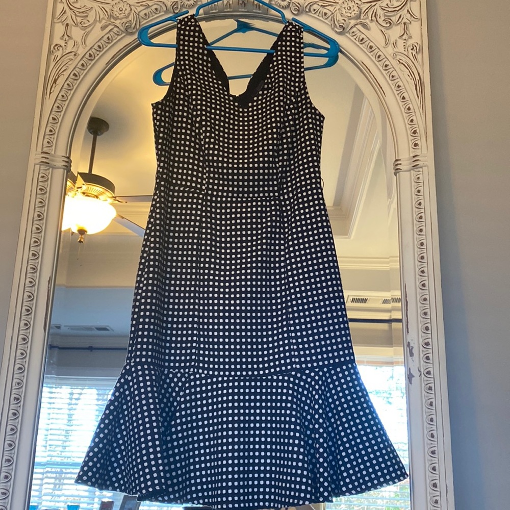 Beautiful black dress with white polka dots and kick pleat hem.